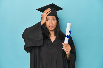 Filipina graduate with diploma on blue studio being shocked, she has remembered important meeting.