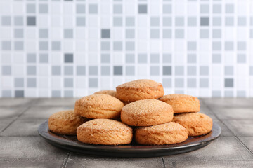 Plate with sweet cookies on grey tile table