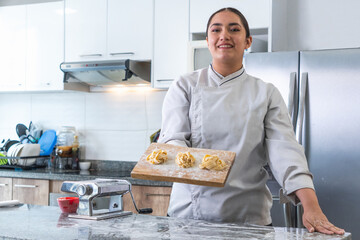 Professional chef presenting fresh homemade tagliatelle pasta in a modern kitchen