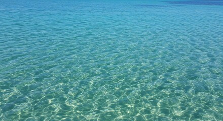 Obraz premium Crystal-clear turquoise water with gentle ripples, sunlight reflections, tranquil mood, serene environment.