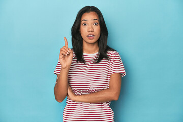 Filipina young woman on blue studio having some great idea, concept of creativity.