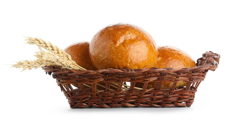 Wicker basket with fresh buns and wheat ears isolated on white background