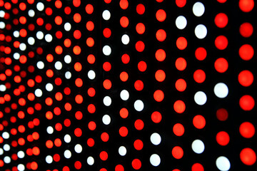 Vibrant Dot Array: A close-up shot reveals a mesmerizing display of red and white dots arranged in a dynamic pattern, creating an optical illusion of depth and movement.