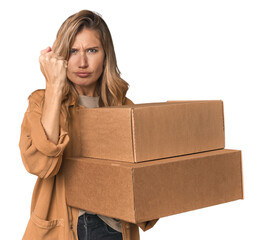 Blonde Caucasian moving with large boxes showing fist to camera, aggressive facial expression.