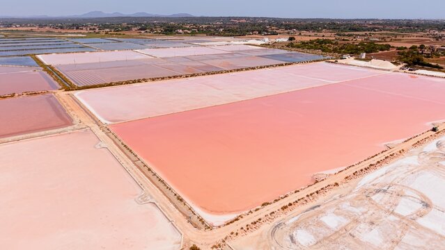 Pink salt evaporation ponds creating a colorful and geometric landscape in es trenc, mallorca