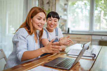 multicultural female friends discussing on video call at home