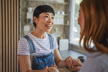 Excited japanese woman share good news with her friend at home