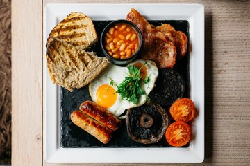 A plate of breakfast food with eggs, bacon, and toast
