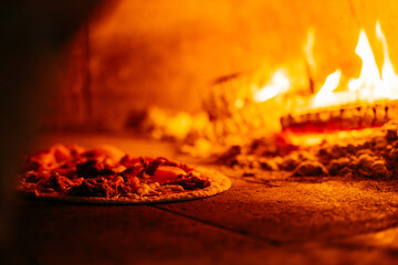 A pizza is being cooked in a wood burning oven