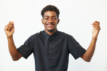 Happy African American man celebrating with raised arms, dressed in a black shirt, expressing joy...