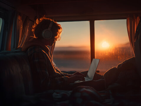 A young freelancer video calling from a camper van at sunset