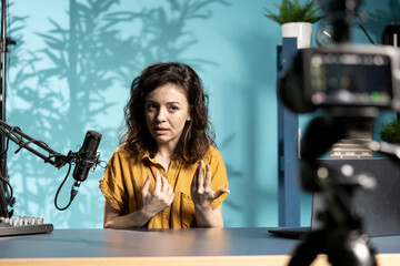 ASMR artist uses quality mic in studio to do anti stress video, whispering sounds. Woman using professional microphone to get sleep inducing high quality audio for meditation