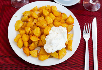 Patatas Bravas, classic Spanish tapas dish, are crispy fried potatoes served with spicy sauce