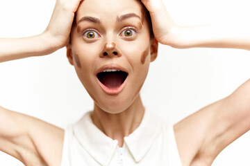 Surprised young woman expressing shock and excitement, featuring a unique makeup style with brown...