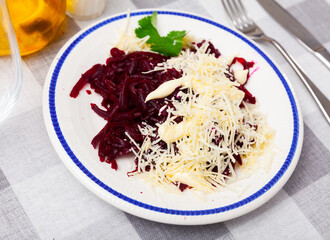 Tasty vitamin salad of sweet grated boiled beets with cheese, piquant mayo and greens. Vegetarian appetizer