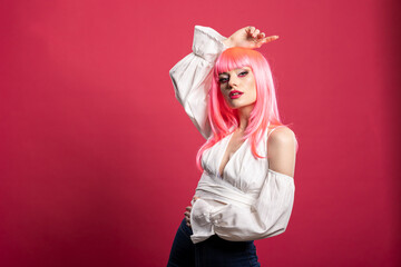 Chic white woman with pink hairstyle and fashionable top looks at camera with calm face. Attractive...