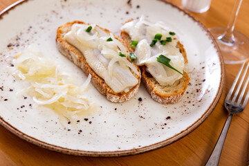 Delicious sandwiches with lightly salted herring fillet garnished with sweetish pickled onions and chopped scallions. Popular European cuisine