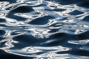 Ripples and reflections in blue water surface