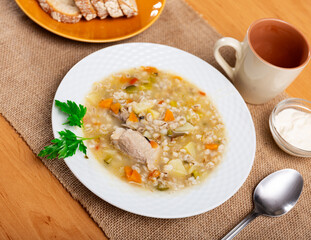 Soup with barley and pickled cucumbers, pearl barley, meat, carrots and potatoes served with bread.