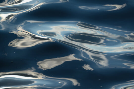 Ripples and reflections in blue water surface