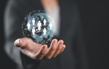 Businessman hand holding a digital sphere with human figure models inside.