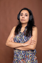Portrait of pretty indian woman standing confidently with arms crossed, looking at camera,...