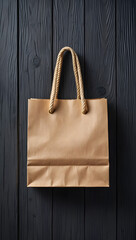 A simple brown paper shopping bag with thick woven handles sits against a textured black wooden background