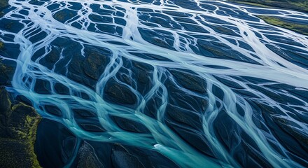 Aerial View of Braided River: An aerial perspective showcases a mesmerizing braided river, its turquoise water weaving intricate patterns across a dark landscape.