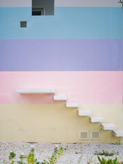 Staircase. A white concrete stair with sweet palette pastel colourful rainbow paint on the wall...