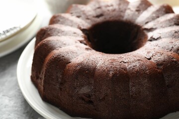 Tasty chocolate bundt cake on grey table, closeup