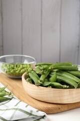 Fresh ripe green peas on white wooden table
