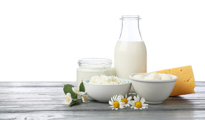 Different fresh dairy products and flowers on grey wooden table against white background