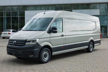 One white minibus parked on paved road outdoors
