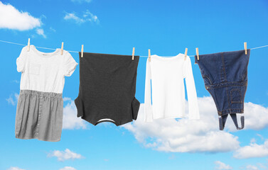 Different clothes drying on washing line against blue sky