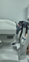 Optical examination taking place in a clinic with multiple patients being tested for vision in a...