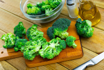 Sliced fresh broccoli on kitchen board with knife. Cooking concept
