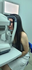 Eye examination taking place in a clinical setting with a patient using diagnostic equipment