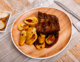 Juicy pork ribs with barbecue sauce served with potatoes
