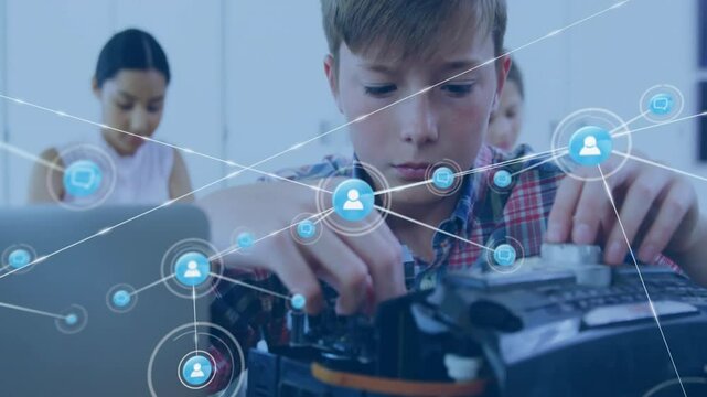 Teen boy adjusting electronics kit causing network icons connecting on bench showing STEM teamwork