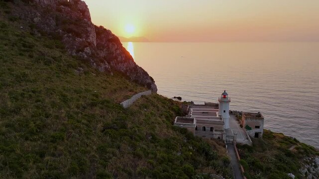 La quiete dopo la tempesta, vista mozzafiato  dall'alto con ripresa da drone  del tramonto che si scaglia sul faro di mongerbino a capo zafferano su scogliera a picco sul mare in sicilia a Palermo