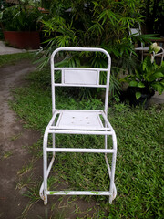Weathered white metal chair frame, hinting at vintage garden furniture or a DIY restoration...