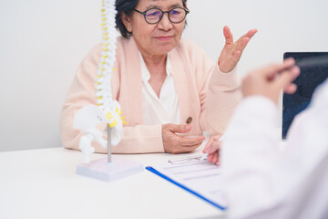 Elderly Patient consulting Doctor with Spine anatomy for Spinal Cord Disorder and disease, Back...