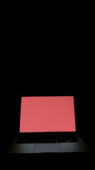 Laptop with a solid red screen in a dark setting.