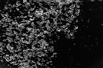 黒の背景に水中に舞い上がるたくさんの気泡.