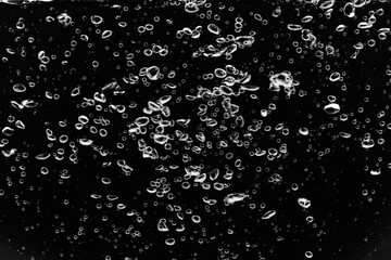 黒の背景に水中に舞い上がるたくさんの気泡.