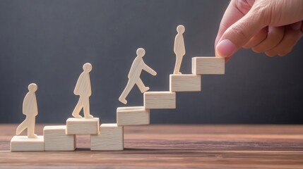 Wooden figures ascend stairs made of blocks, symbolizing growth, progress, and support, with a hand placing the final step.