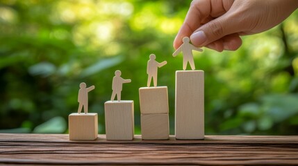 Four wooden human figures stand on ascending blocks, with a hand placing the tallest figure, symbolizing growth and progress.