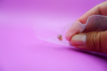 Hand Holding a Ziplock Bag with a Baby Tooth