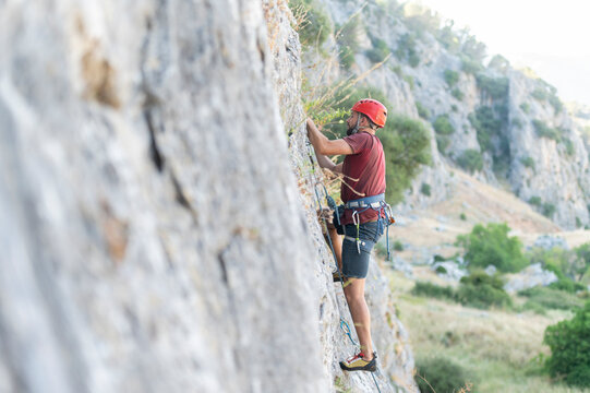 Adventurous Climber Scaling a Steep Mountain Face