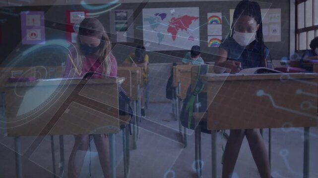 Two schoolgirls writing at school desks, lifting heads and bumping elbows for contactless greeting